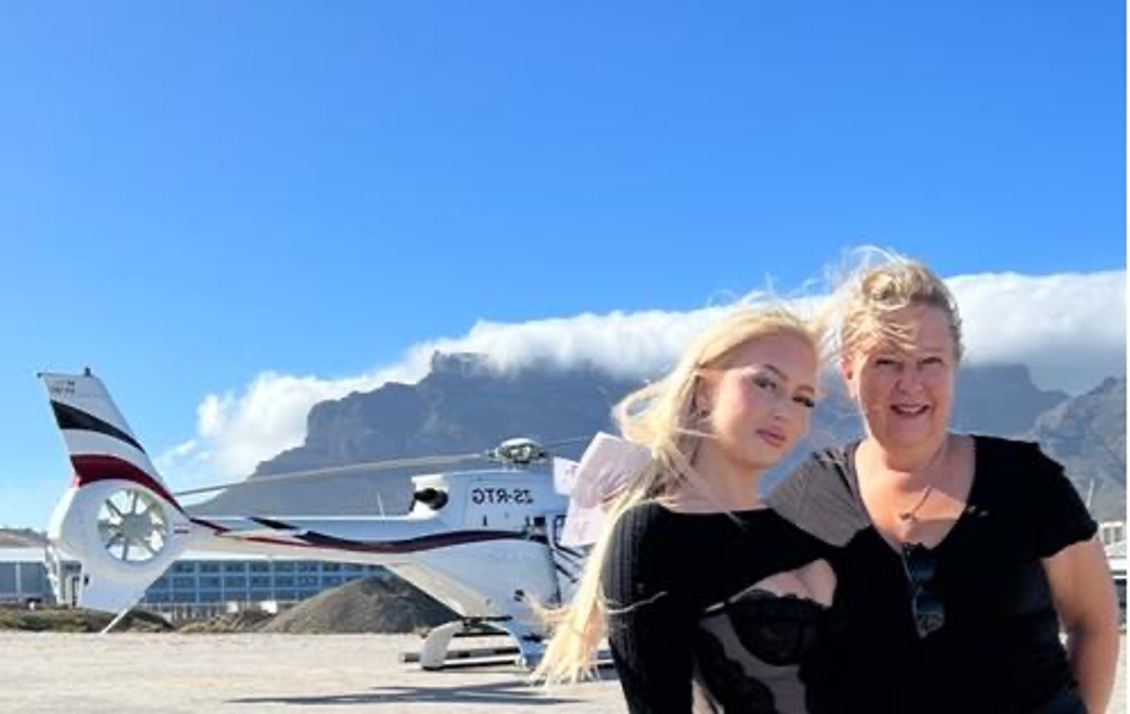 De auteur met haar dochter voor de helikopter in Zuid-Afrika